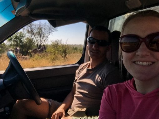 Nós, dentro do carro, com as zebras ao fundo no parque Kruger.