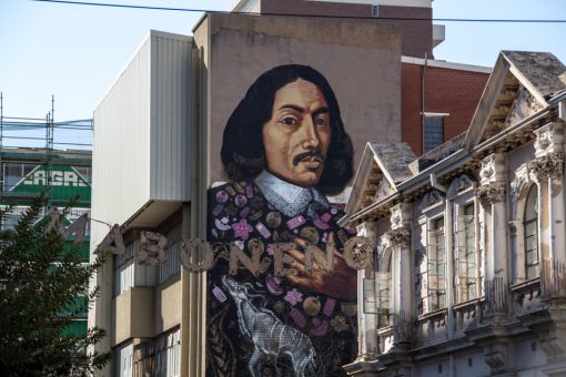 Grafite de um homem com roupas antigas e o letreiro Maboneng